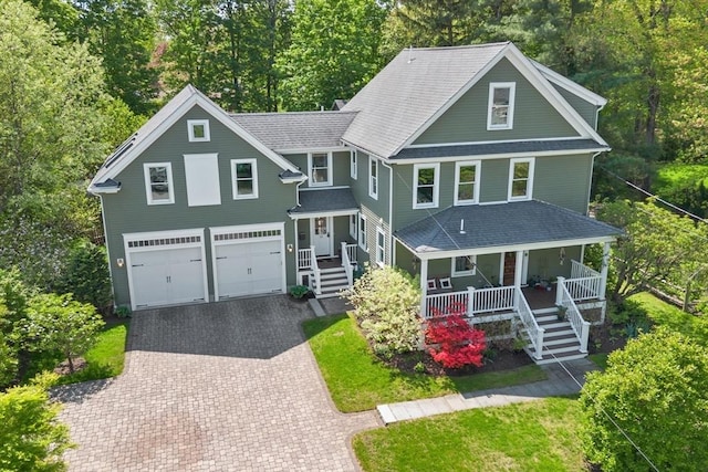 18 Hill St, Lexington, MA 02421 - view of front facade with covered porch, decorative driveway, a garage, a shingled roof, and view of wooded area
