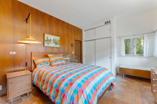 bedroom with a closet and wood walls