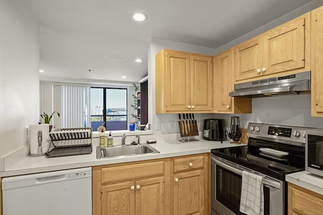 kitchen featuring appliances with stainless steel finishes, under cabinet range hood, a sink, light brown cabinetry, and recessed lighting