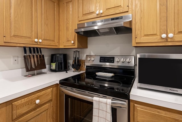 kitchen with appliances with stainless steel finishes, under cabinet range hood, and light countertops