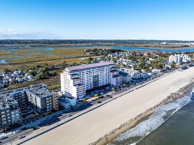 drone / aerial view of expansive coastline and apartment complex