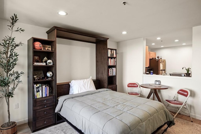 bedroom with baseboards, recessed lighting, freestanding refrigerator, and light wood finished floors