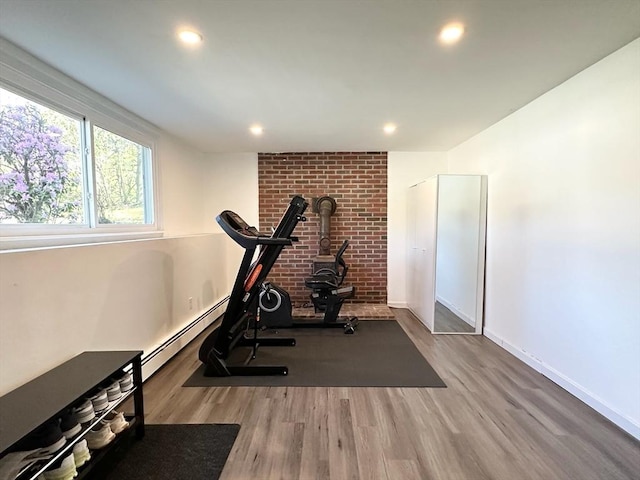 197 Winn St, Burlington, MA 01803 - exercise room featuring recessed lighting, a wood stove, baseboards, and wood finished floors