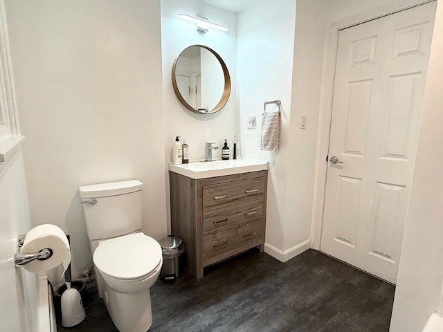 197 Winn St, Burlington, MA 01803 - half bath with vanity, baseboards, toilet, and wood finished floors