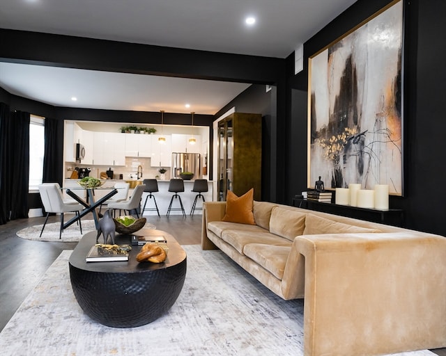 living room featuring beam ceiling and concrete flooring