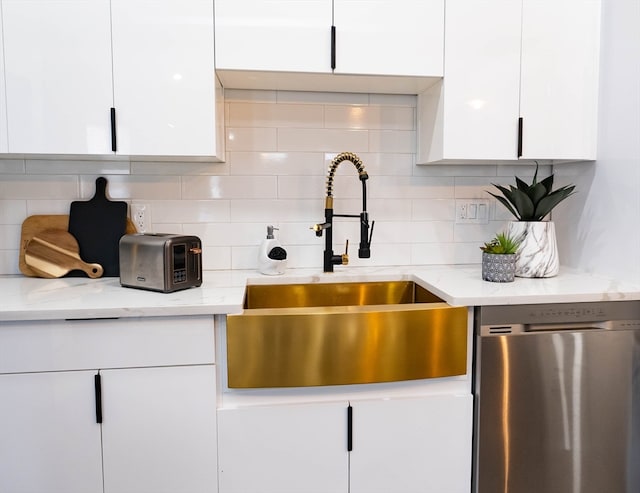 kitchen with sink, light stone counters, decorative backsplash, stainless steel dishwasher, and white cabinetry