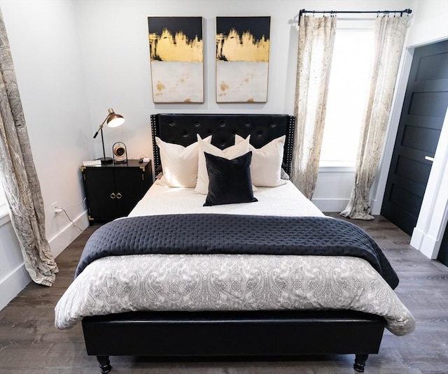 bedroom featuring baseboards and wood finished floors