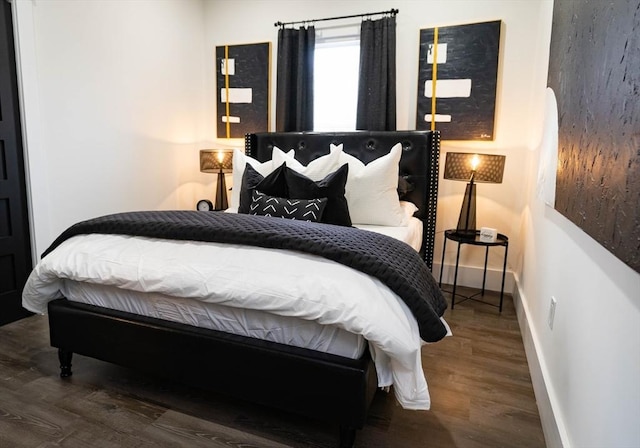 bedroom featuring baseboards and wood finished floors