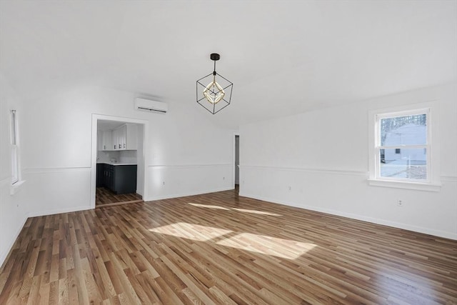 unfurnished living room with an AC wall unit and dark wood-type flooring