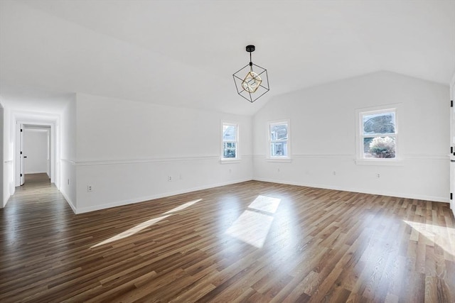 unfurnished living room featuring dark wood-type flooring and lofted ceiling