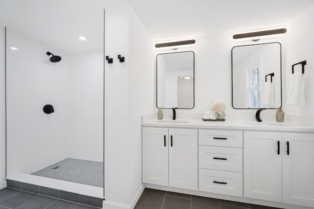 bathroom with a tile shower, tile patterned flooring, and vanity