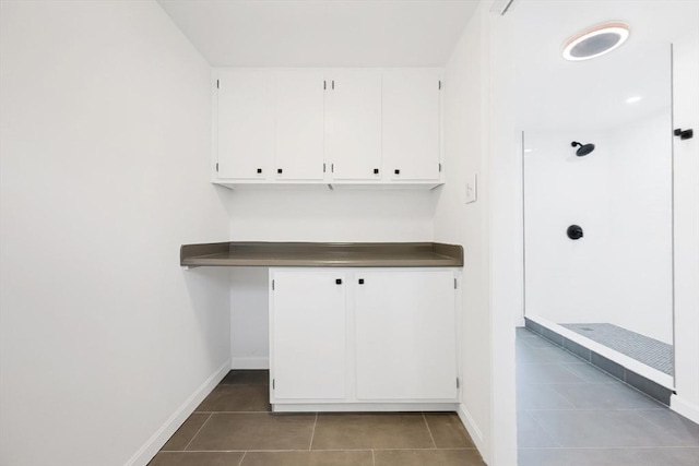 mudroom with dark tile patterned floors