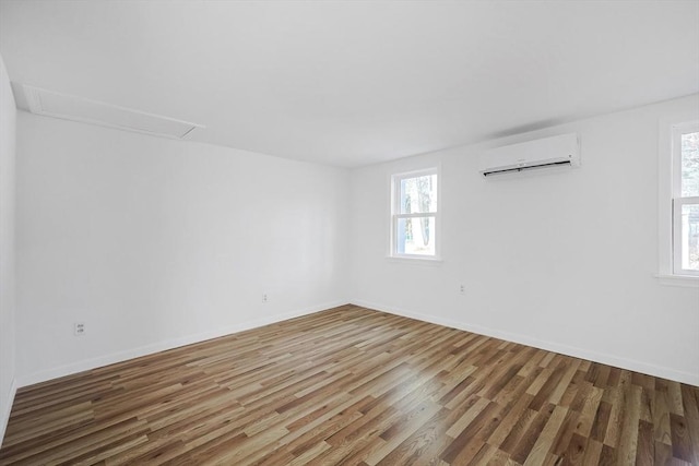 empty room with wood-type flooring and a wall mounted AC