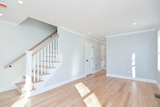 empty room featuring ornamental molding and light hardwood / wood-style flooring