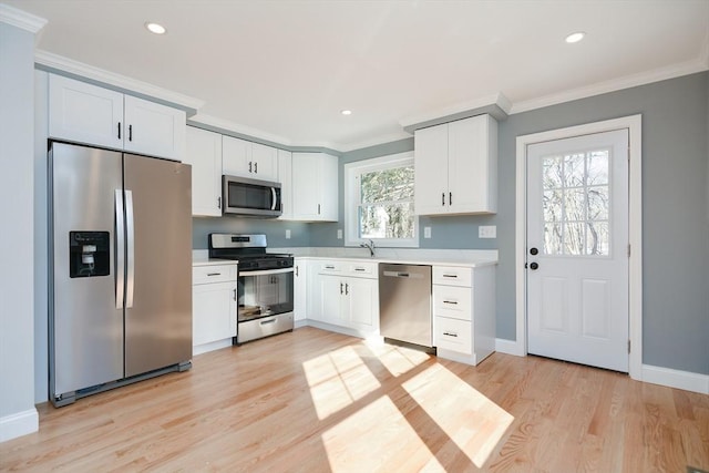 kitchen featuring crown molding, white cabinets, and appliances with stainless steel finishes