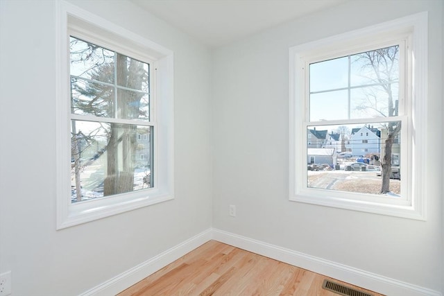 empty room featuring hardwood / wood-style flooring and a healthy amount of sunlight