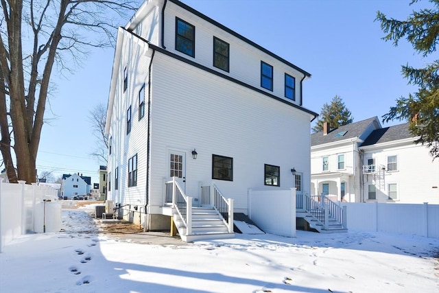 view of snow covered rear of property