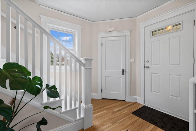 entrance foyer with baseboards, light wood-style flooring, and stairway