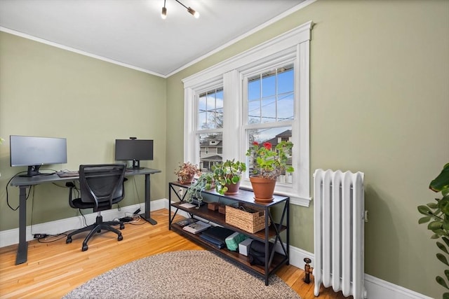 office area with baseboards, ornamental molding, radiator, and wood finished floors