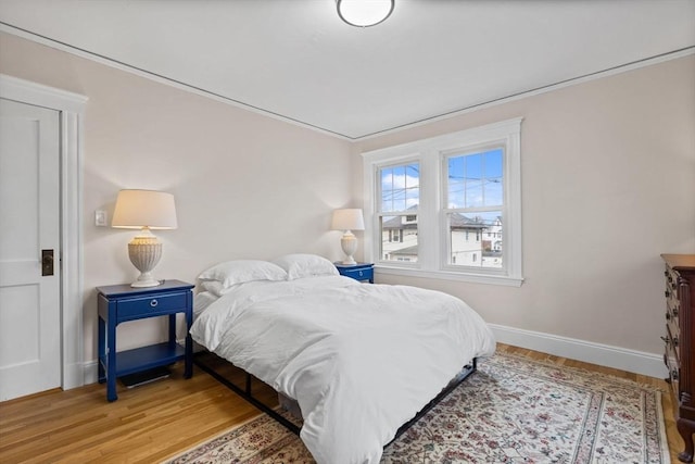 bedroom with baseboards and light wood-type flooring