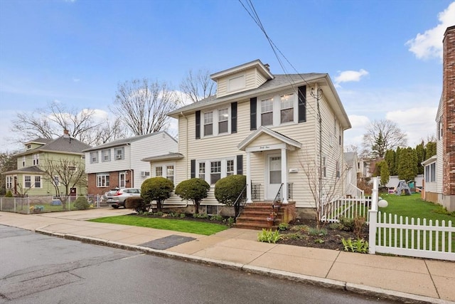 american foursquare style home with fence and a residential view