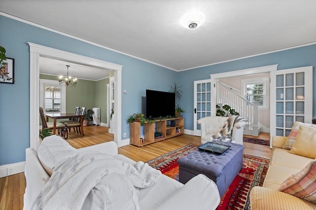 living area with an inviting chandelier, crown molding, stairway, and plenty of natural light