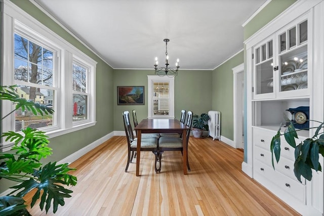 dining area featuring baseboards, ornamental molding, and an inviting chandelier