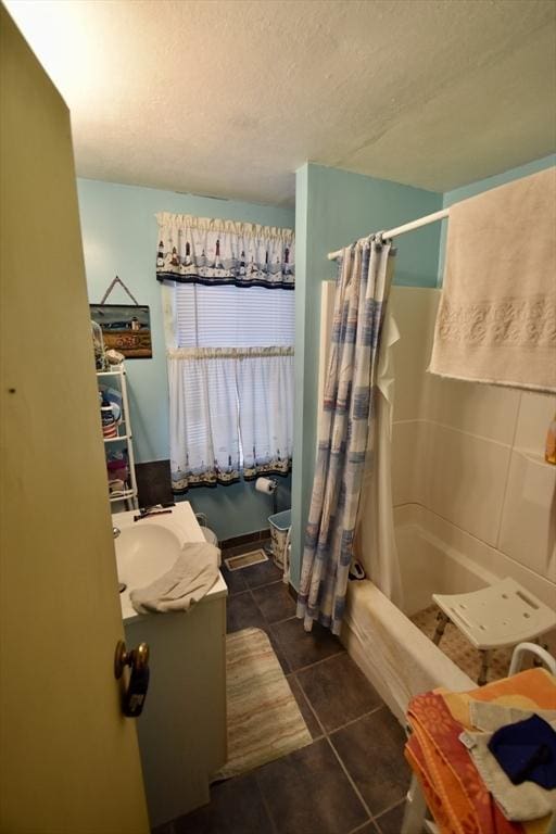 bathroom featuring shower / bathtub combination with curtain, a textured ceiling, vanity, and tile patterned flooring