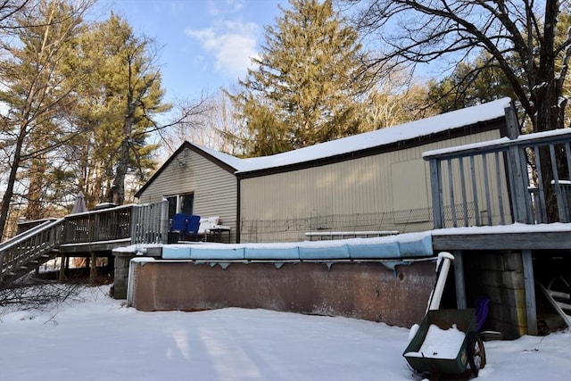 view of snow covered exterior with a wooden deck