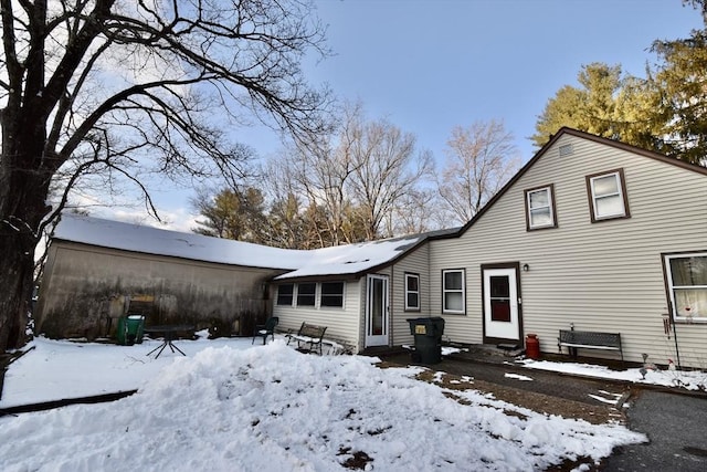 snow covered rear of property with entry steps