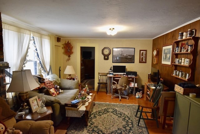 living area with wallpapered walls, wood finished floors, and ornamental molding