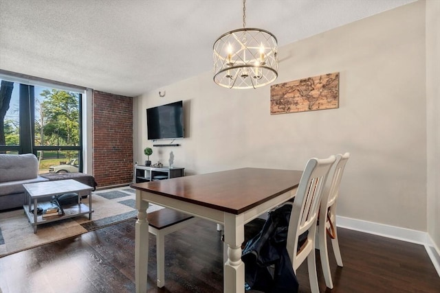 dining space with baseboards, dark wood-style floors, a textured ceiling, and a notable chandelier