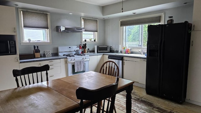 10 Arbutus Rd, Worcester, MA 01606 - kitchen with black appliances, under cabinet range hood, white cabinetry, a sink, and light wood-type flooring