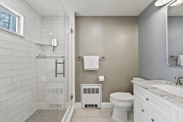 full bath with vanity, toilet, tile patterned floors, radiator, and a stall shower