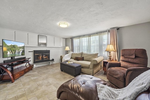 living area with a brick fireplace and a textured ceiling