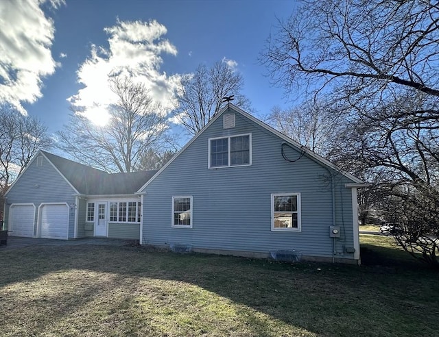 view of home's exterior with a garage and a yard