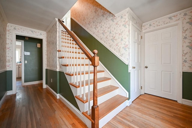 staircase featuring hardwood / wood-style flooring and ornamental molding