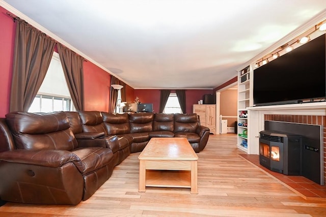 living room with light hardwood / wood-style floors, a wood stove, and crown molding