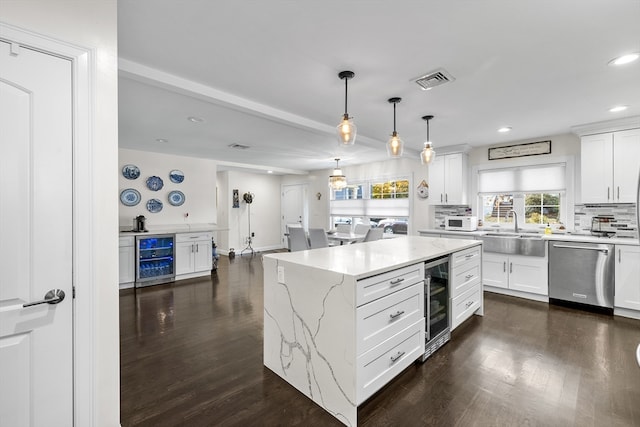 kitchen featuring a center island, white cabinetry, stainless steel dishwasher, and sink