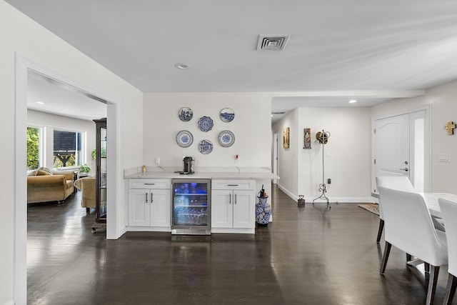 bar featuring white cabinetry, wine cooler, and dark hardwood / wood-style floors