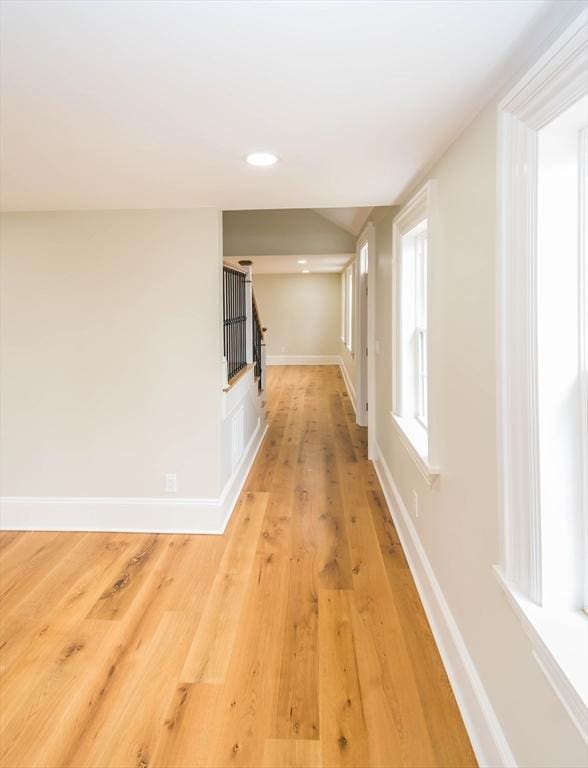 corridor featuring recessed lighting, baseboards, and light wood finished floors