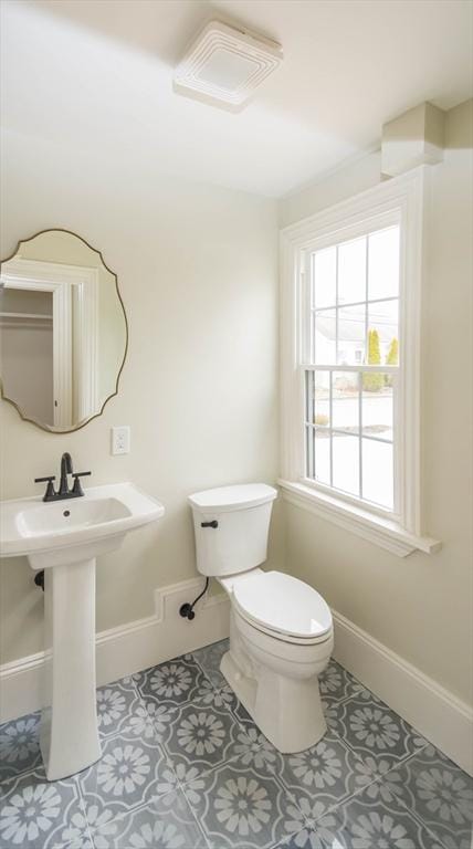 bathroom with tile patterned flooring, toilet, baseboards, and a sink