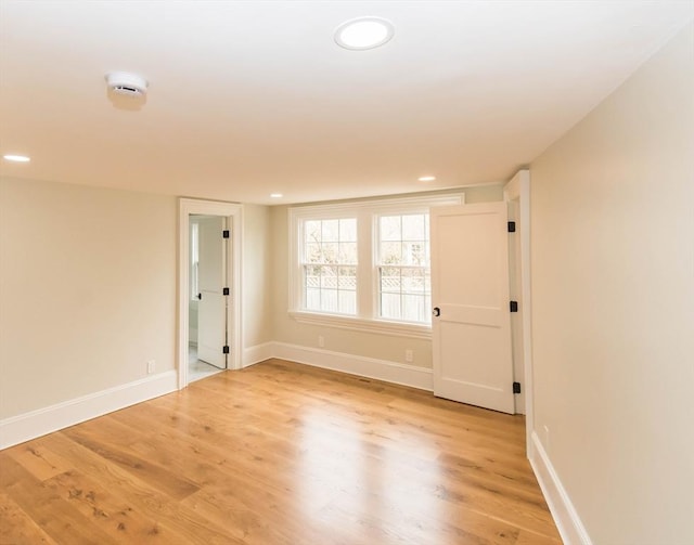 spare room featuring recessed lighting, light wood-style floors, and baseboards
