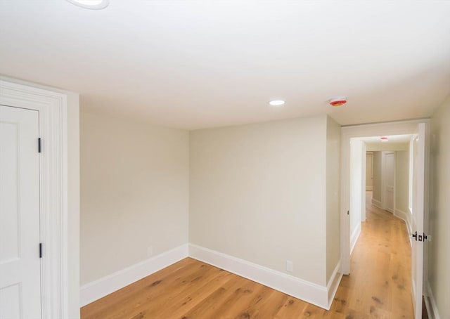 empty room with recessed lighting, light wood-style flooring, and baseboards