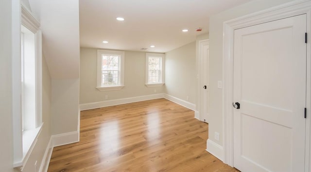 spare room featuring recessed lighting, baseboards, and light wood finished floors