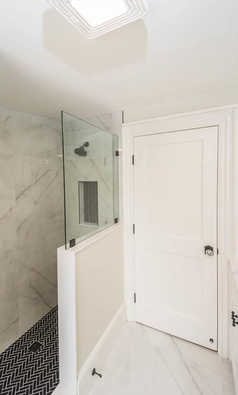 full bath with a marble finish shower and marble finish floor