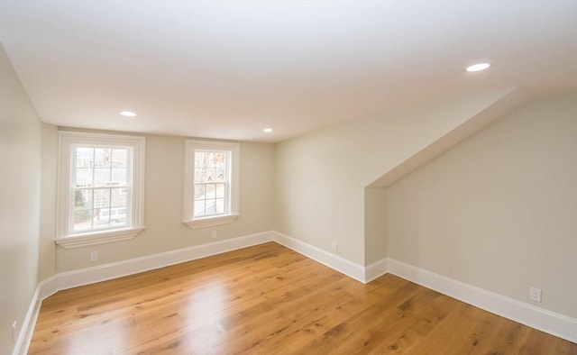 spare room featuring recessed lighting, light wood-style floors, and baseboards