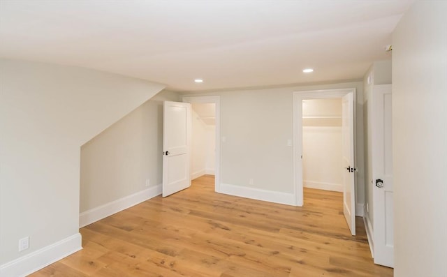 additional living space with recessed lighting, light wood-style floors, and baseboards