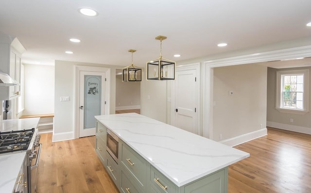 kitchen featuring light wood finished floors, a kitchen island, recessed lighting, appliances with stainless steel finishes, and pendant lighting