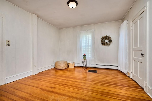 154 N Maple St, Northampton, MA 01062 - empty room with a baseboard heating unit and wood finished floors